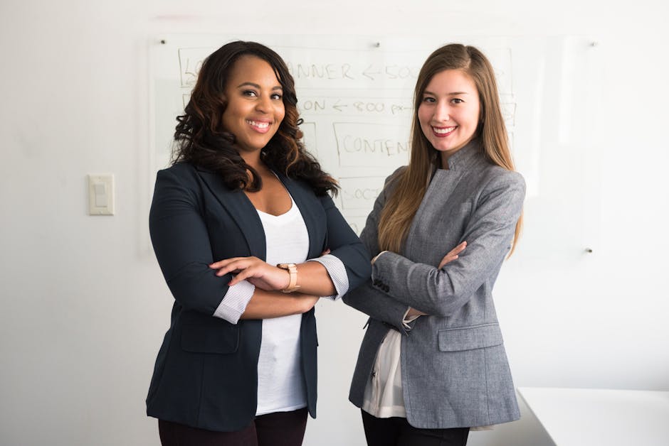 pexels-photo-1181527-1181527 Two diverse businesswomen smiling confidently in a modern office environment.